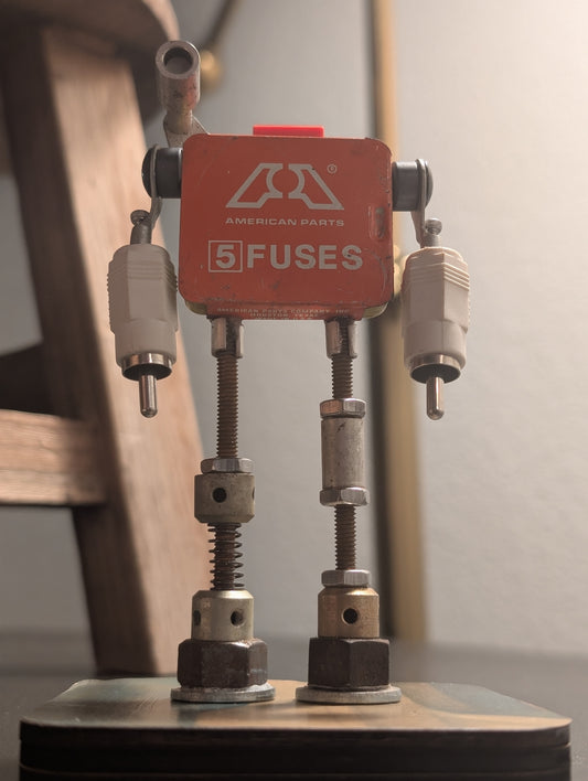 R3BOTS American Sentinel AF-5: Premium upcycled metal art and industrial desk decor featuring authentic automotive salvage and handcrafted mid-century mechanical details.