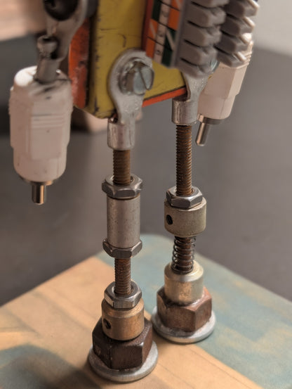 Three-view composite (front, leg detail, left profile) of the American Sentinel AF-5 robot sculpture, highlighting the threaded steel leg construction and vintage orange American Parts tin body.