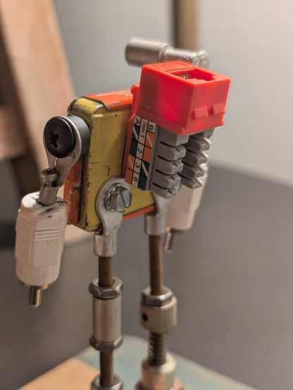 Three-angle view (front, right, left) of a handmade American Parts fuse tin robot sculpture featuring upcycled RCA connector arms and industrial steel hardware.